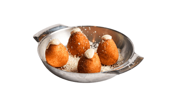 Quatro coxinhas douradas em travessa de metal, polvilhadas com parmesão