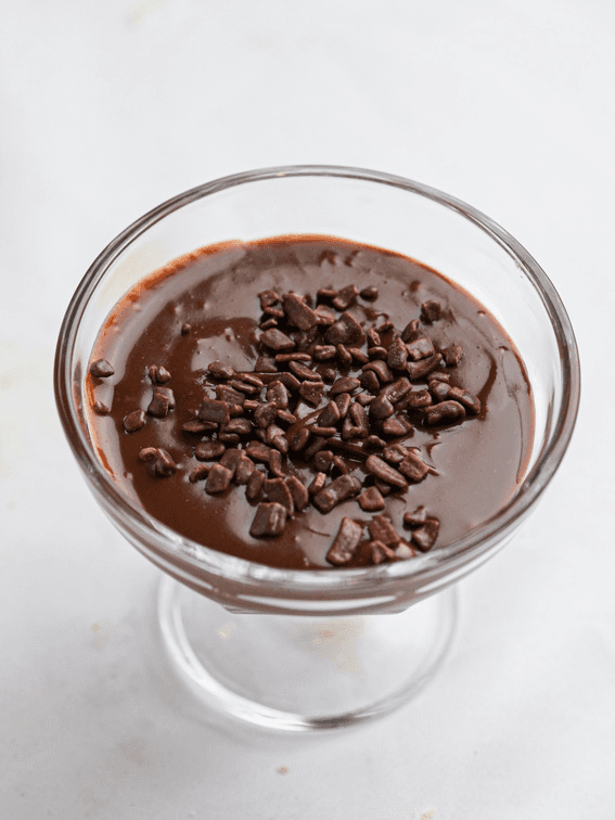 Taça de vidro com brigadeiro cremoso coberto por raspas de chocolate